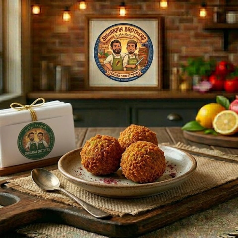 Three crispy falafel balls on a plate, with Shawarma Brothers branding and lemons in the background.